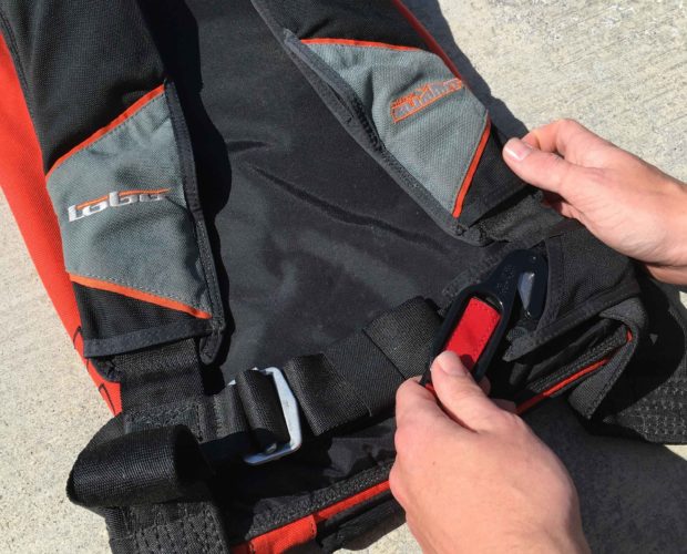 Hands fastening black and red life jacket
