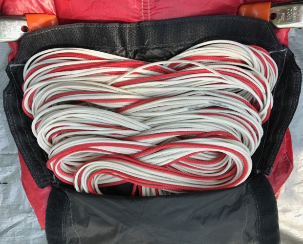Coiled red and white rope in black bag